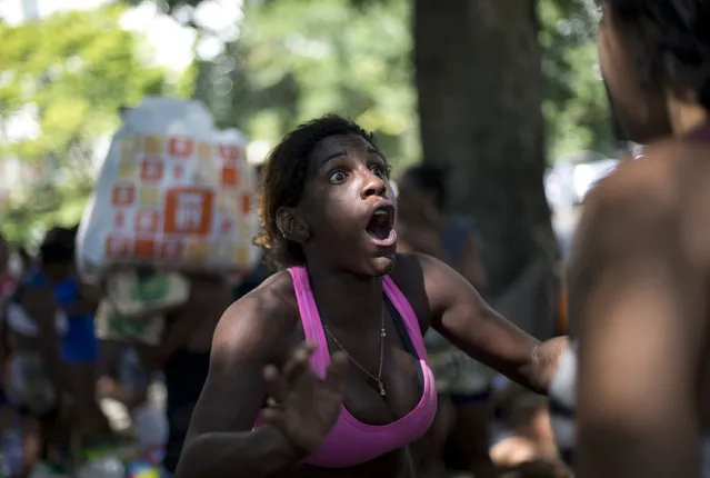 A woman protests her eviction from a building she and others invaded about a week ago in the Flamengo neighborhood of Rio de Janeiro, Brazil, Tuesday, April 14, 2015. Police dislodged squatters from the building slated for use as a luxury hotel for the 2016 Olympics in Rio de Janeiro. (Photo by Silvia Izquierdo/AP Photo)