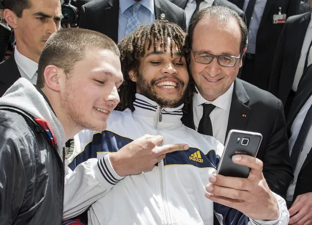 Two men take a selfie with French President Francois Hollande, right, at the “Muensterplatz” square in Bern, Switzerland, Wednesday, April 15, 2015. Hollande is on a two-day official visit in Switzerland. (Photo by Thomas Hodel/Keystone via AP)