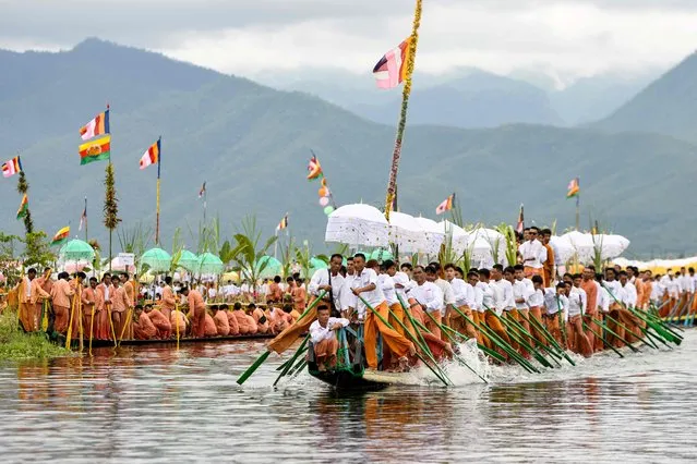 This photo taken on October 18, 2023, shows devotees rowing as they follow the four sacred Buddha images placed on a golden barge during the festival of Phaung Daw Oo Pagoda in Inle Lake, Myanmar's Shan State. Thousands of Buddhist devotees joined a waterborne procession on Myanmar's Inle lake as one of the country's biggest festivals returned to joy and sorrow as conflict between the military and its opponents rages on. (Photo by Sai Aung Main/AFP Photo)