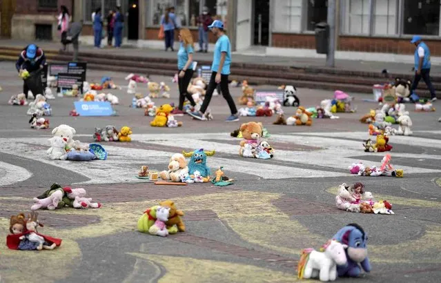 Toys cover the plaza, 20 of July, where they were placed by people protesting violence against children in Bogota, Colombia, Tuesday, November 22, 2022. Stuffed animals, dolls and action figures were laid out to also demand more funding for organizations that help children who are growing up without their biological parents. (Photo by Fernando Vergara/AP Photo)