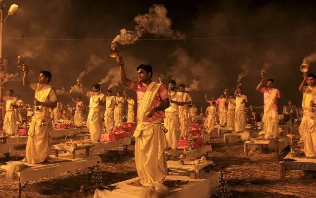 Hindu priests hold traditional incense lamps as they perform a ritual known as “Aarti” on the banks of Sangam – the confluence of the Ganges, Yamuna and mythical Saraswati rivers – during the annual religious festival of Magh Mela in Allahabad, India, February 14, 2016. The festival is an annual religious event held during the Hindu month of Magh, when thousands of devotees take a holy dip at Sangam. (Photo by Jitendra Prakash/Reuters)