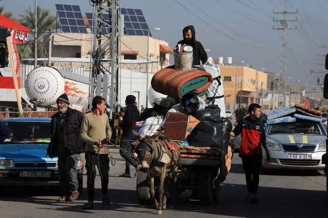 Palestinians transport belongings on an animal-drawn cart, as they flee their houses after they were ordered by the Israeli army to evacuate the area, in Bureij in the central Gaza Strip on December 26, 2023. (Photo by Mohammed Al-Masri/Reuters)