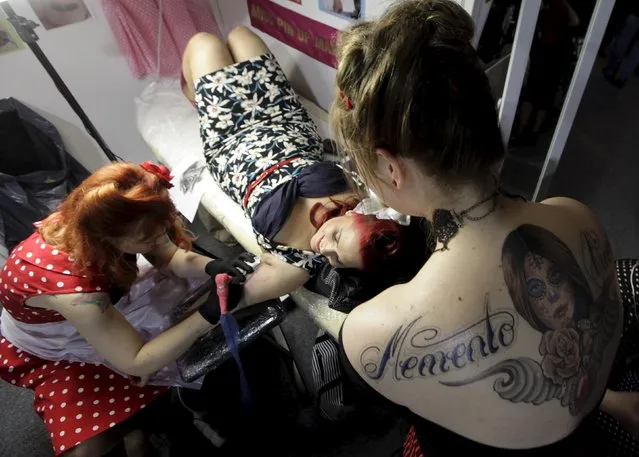 An artist draws a tattoo on a woman's arm during a tattoo convention in Ljubljana April 18, 2015. (Photo by Srdjan Zivulovic/Reuters)