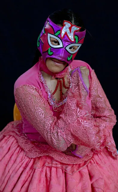 Young cholita wrestler Nelly Pankarita strikes a pose wearing her mask after competing in the ring in El Alto, Bolivia, Sunday, February 10, 2019. The 17-year-old Nieves Laura Tarqui wrestles with the ring name Nelly Pankarita, with Pankarita translating as “Little Flower” in Aymara. (Photo by Juan Karita/AP Photo)