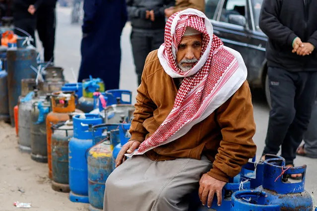 A Palestinian man waits to fill his cylinders with cooking gas amid shortage, as the conflict between Israel and Hamas continues, in Rafah, in the southern Gaza Strip on January 11, 2024. (Photo by Ibraheem Abu Mustafa/Reuters)