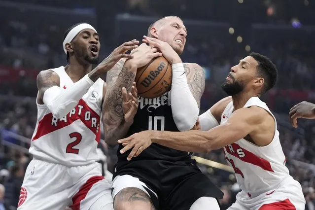 Toronto Raptors forward Jalen McDaniels, left, and forward Garrett Temple, right, try to tie up Los Angeles Clippers center Daniel Theis during the first half of an NBA basketball game Wednesday, January 10, 2024, in Los Angeles. (Photo by Mark J. Terrill/AP Photo)