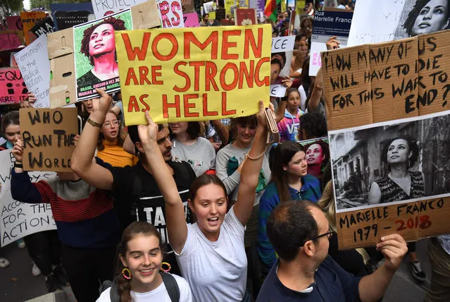 People hold up banners as thousands march to mark International Women's Day in Melbourne, Australia on March 8, 2019. (Photo by William West/AFP Photo)