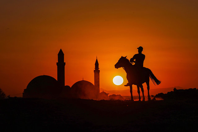 A silhouette of a mounted man near Kaya Celebi and Husrev Pasha Mosques located at the south of Van Castle during sunset in Van, Turkey on September 06, 2021. (Photo by Ozkan Bilgin/Anadolu Agency via Getty Images)