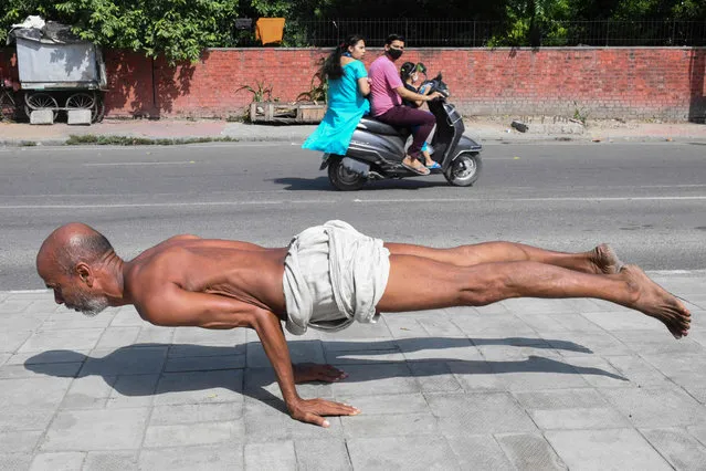 A man practices yoga along a footpath in Amritsar on October 6, 2021. (Photo by Narinder Nanu/AFP Photo)