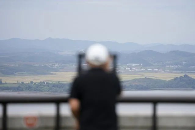 A visitor uses binoculars to see the North Korean side from the unification observatory in Paju, South Korea, Tuesday, September 28, 2021. North Korea fired a short-range missile into the sea early Tuesday, its neighboring countries said, in the latest weapon tests by North Korea that has raised questions about the sincerity of its recent offer for talks with South Korea. (Photo by Lee Jin-man/AP Photo)