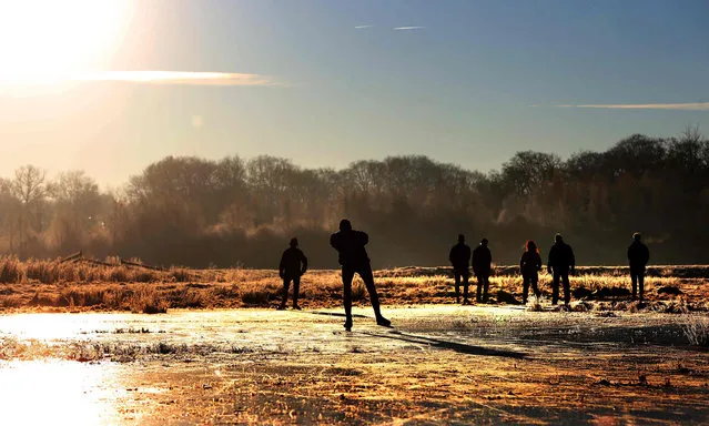 The first skaters on nature ice in the Ryptsjerksterpolder in Tietjerk, on December 5, 2016. (Photo by Catrinus van der Veen/AFP Photo/ANP)