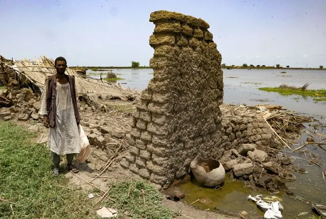 A Sudanese man inspects a house, damaged due to floods, in the al-Qanaa village in Sudan's southern White Nile state on September 14, 2021. Last year, Sudan was forced to declare a three-month state of emergency after facing “the worst flooding” in a century that killed around 140 people and affected some 900,000 people, according to the United Nations. The floods this year have so far killed around 84 people nationwide and damaged or destroyed around 35,000 homes nationwide, Sudanese authorities said. (Photo by Ashraf Shazly/AFP Photo)