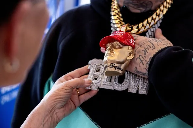 Rapper Forgiato Blow shows a person his Trump-themed jewelry at the Conservative Political Action Conference (CPAC) annual meeting in National Harbor, Maryland, U.S., February 22, 2024. (Photo by Amanda Andrade-Rhoades/Reuters)