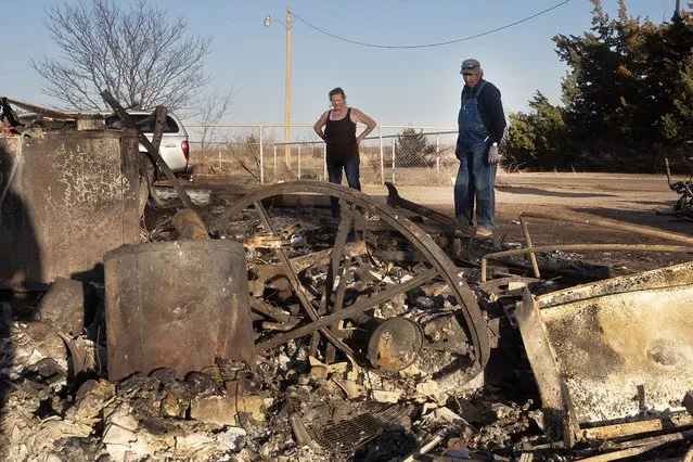 Vernon Jones helps his wife Melissa clean debris from her father's property after a garage and carport were destroyed by the Smokehouse Creek fire on March 03, 2024 near Stinnett, Texas. The fire has burned more than a million acres in the Texas Panhandle, killing at least two people and destroying more than 500 structures. (Photo by Scott Olson/Getty Images)