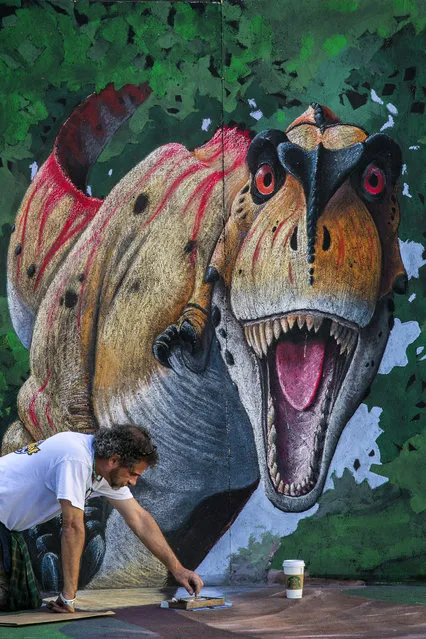 Mike Las Casas, of Palm Beach Gardens, paints the foot of a dinasour. (Photo by Greg Lovett/The Palm Beach Post)