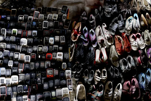 Used shoes and cell phones fill a wall at a market set up by residents under a road bridge in Caracas, Venezuela, Wednesday, March 20, 2019. Residents desperate for cash transform patches of sidewalk into their impromptu shops, laying out old shoes or second-hand shirts as merchandise. (Photo by Natacha Pisarenko/AP Photo)