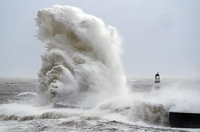 Huge waves crash the against the lighthouse in Seaham Harbor after gusts of almost 100 miles (160 km) per hour battered some areas of the country during Storm Arwen, in Durham, England, Saturday November 27, 2021. The Met Office issued a rare red warning for wind from 3pm on Friday to 2am on Saturday as the first winter storm was set to batter the country. (Photo by Owen Humphreys/PA Wire via AP Photo)