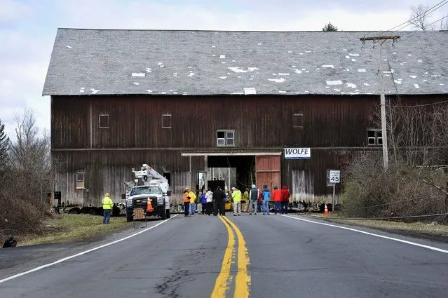 Spectators gather to watch as workers with Wolfe House and Building Movers move the 1898 Hilton Barn at LeVie Farm across Maple Avenue on Tuesday, March 29, 2016, in Slingerlands, N.Y. The post-and-beam barn is 120 feet long, 60 feet tall and 60 feet wide. (Photo by Paul Buckowski/The Albany Times Union via AP Photo)
