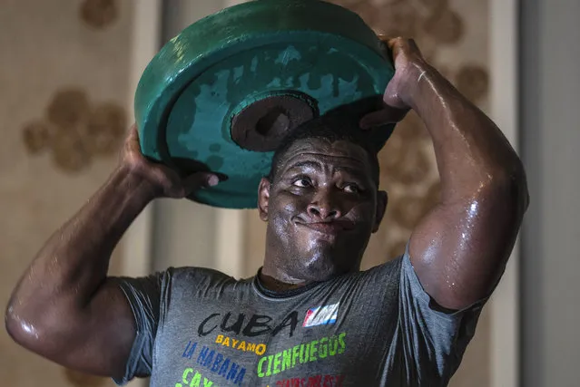 Greco-Roman wrestler Cuba's Mijain Lopez Nunez lifts weights during a training session in Varadero, Cuba, Wednesday, April 3, 2024. Lopez will be part of the Cuban delegation to Paris in pursuit of a fifth Olympic gold to mark the end of his career. (Photo by Ramon Espinosa/AP Photo)