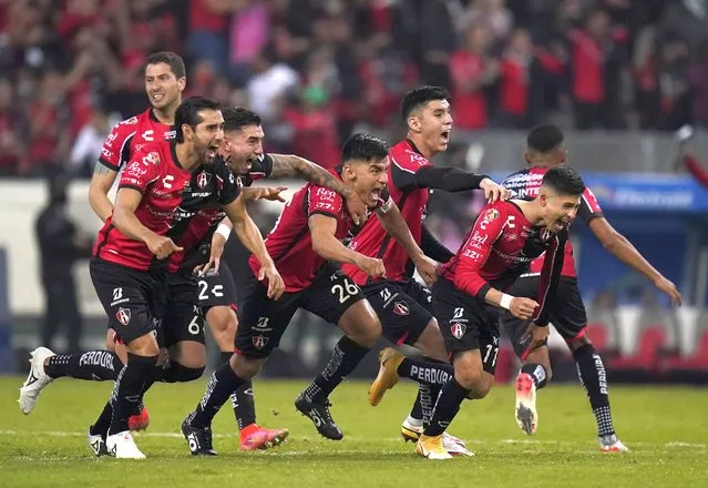 Mexico's Atlas players celebrate after their teammate Julio Furch scored a penalty shot against Mexico's Leon during a Mexican soccer league final match in Guadalajara, Sunday, December 12, 2021. (Photo by Eduardo Verdugo/AP Photo)