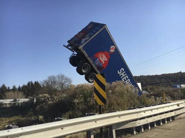The trailer of an articulated lorry juts into the air after the vehicle came off a bridge on Interstate 81 southbound in Butler Township in Pennsylvania, US on November 9, 2021. (Photo by Sean McKeag/AP Photo)