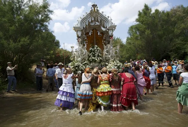 Pilgrims push a carriage as they cross Quema river on their way to the shrine of El Rocio in Aznalcazar, southern Spain May 21, 2015. (Photo by Marcelo del Pozo/Reuters)