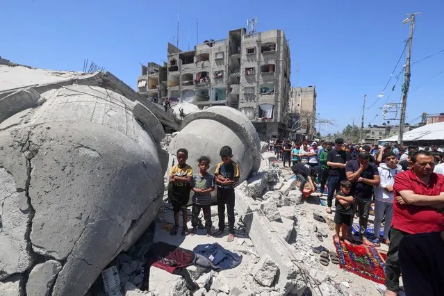 Palestinians perform Friday noon prayer on April 19, 2024, next to the ruins of Al-Farouq Mosque, destroyed during Israeli bombardment in Rafah in the southern Gaza Strip, amid ongoing battles between Israel and the militant group Hamas. (Photo by Mohammed Abed/AFP Photo)