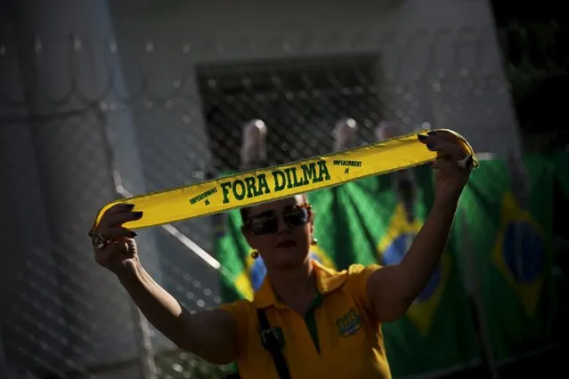 A demonstrator holds a small banner reading “Out Dilma” during a protest against Brazil's President Dilma Rousseff at Paulista Avenue in Sao Paulo, Brazil, April 17, 2016. (Photo by Nacho Doce/Reuters)