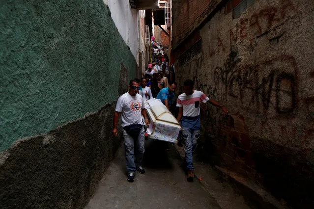 Relatives carry a coffin containing the body of Erick Altuve, a 11-year-old boy who died from respiratory problems while in care for stomach cancer at the public Jose Manuel de los Rios hospital, at Petare neighborhood in Caracas, Venezuela, May 30, 2019. (Photo by Ivan Alvarado/Reuters)