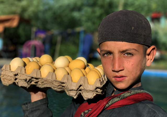 An Afghan child selling boiled eggs at a picnic spot on the outskirts of Kabul, Afghanistan, 16 July 2019. Due to poverty a huge number of Afghan students are not able to continue their education, instead they are forced to work on the streets to be the bread winners of the family. (Photo by Jawad Jalali/EPA/EFE)