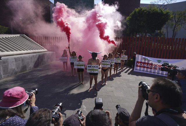 Demonstrators wearing horns and smeared with fake blood to depict bulls stabbed in bullfights, gather outside Congress to ask legislators to approve the initiative to ban bullfighting that is currently before the Environmental Commission, in Mexico City, Tuesday, February 21, 2023. (Photo by Marco Ugarte/AP Photo)
