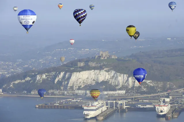 Some of the 100 balloons taking part in a World Record attempt for a mass hot air balloon crossing of the English Channel, fly over the Port of Dover in Kent, England, Friday April 7, 2017. (Photo by Victoria Jones/PA Wire via AP Photo)