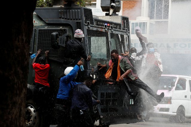 Demonstrators climb on a police vehicle as police use water cannons to disperse protesters during a demonstration against Kenya's proposed finance bill 2024/2025 in Nairobi, Kenya, on June 25, 2024. (Photo by Monicah Mwangi/Reuters)