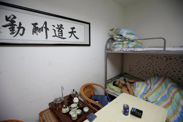 Liu Zhanyu, a client manager at DouMiYouPin, watches a video at a dormitory in the office after finishing work at midnight, in Beijing, China, April 21, 2016. (Photo by Jason Lee/Reuters)