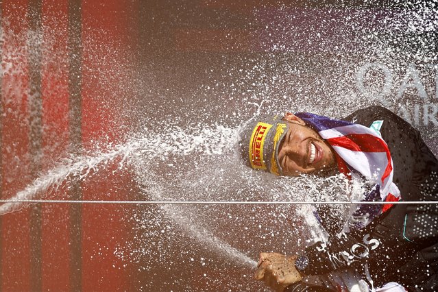 Mercedes' British driver Lewis Hamilton celebrates on the podium with champagne after winning the Formula One British Grand Prix at the Silverstone motor racing circuit in Silverstone, central England, on July 7, 2024. (Photo by Benjamin Cremel/AFP Photo)