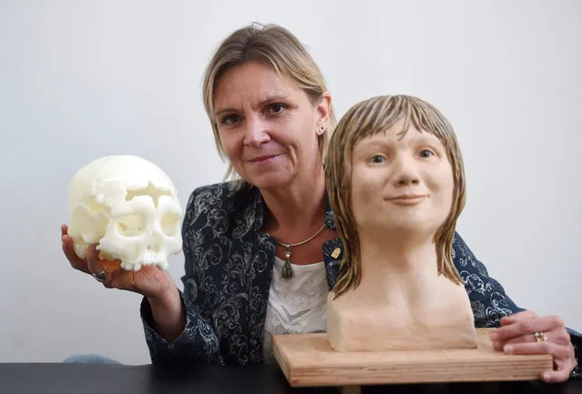 Medical examiner Constanze Niess presents the reconstructed face from a skull from a woman who died over 5,000 years ago at the Kunstquartier in Hagen, Germany, 17 July 2015. Next to it she is holding a replica of the orginally discovered skull. Spelaeologists discovered the skull along with other skeletal remains in the “Blaetterhoehle” (lit.: leaves cave) in Hagen, Westphalia in 2004. (Photo by Jonas Guettler/EPA)