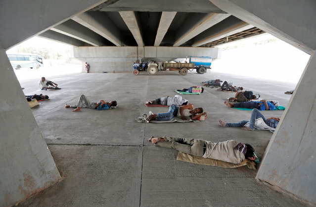 People sleep under a bridge on a hot summer day in Ahmedabad, India May 18, 2016. (Photo by Amit Dave/Reuters)