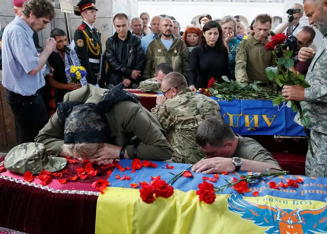 People take part in a funeral ceremony for Mykola Kuliba and Serhiy Baula, servicemen from the “Aydar” battalion, who were killed in the fighting in eastern Ukraine, at Independence Square in central Kiev, Ukraine, May 26, 2016. (Photo by Gleb Garanich/Reuters)