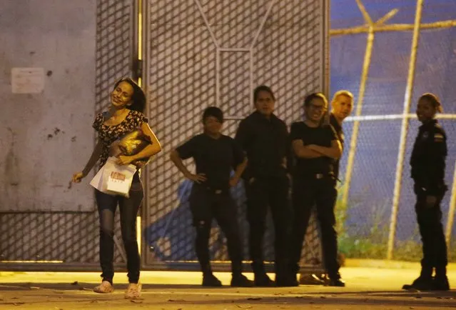 Karen Palacios, left, runs to her family after being released from prison in Los Teques on the outskirts of Caracas, Venezuela, Tuesday, July 16, 2019. Palacios who plays the clarinet and was cut from the National Philharmonic for criticizing the government, and who was detained for 6 weeks, was released today. (Photo by Ariana Cubillos/AP Photo)