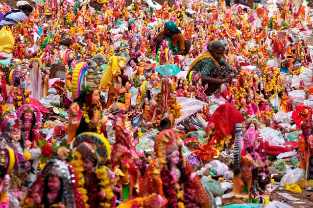 Women search for reusable material amid offerings and idols of Hindu goddess Dashama left by devotees on the banks of River Sabarmati after the end of the ten-days long Dashama festival in Ahmedabad, India, Wednesday, August 14, 2024. (Photo by Ajit Solanki/AP Photo)