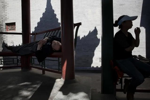 A man sleeps under a pavilion during a warm day in Beijing, China, Monday, May 16, 2016. As summer approaches, throngs of visitors are expected to visit the Chinese capital, a popular destination for both domestic and foreign tourists. (Photo by Ng Han Guan/AP Photo)