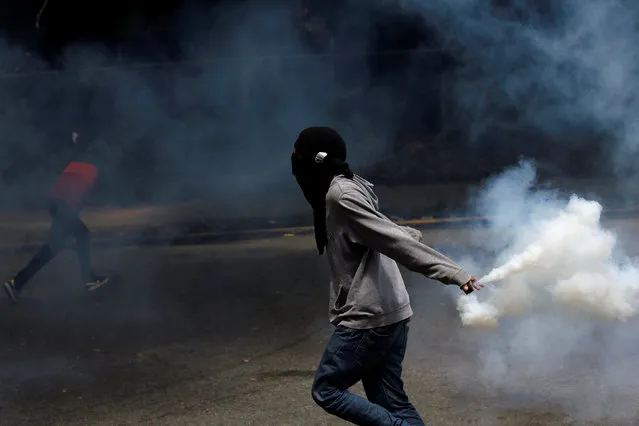 A demonstrator holds a tear gas canister as they clash with riot police officers during a protest called by university students against Venezuela's government in Caracas, Venezuela, June 9, 2016. (Photo by Carlos Garcia Rawlins/Reuters)