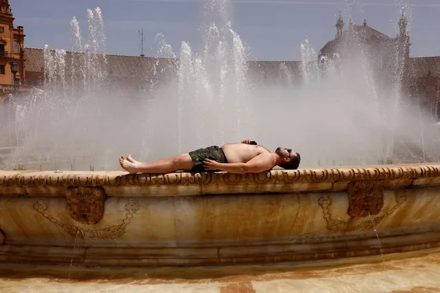 A fan cools off in Seville ahead of the Europa League final in Seville, Spain on May 18, 2022. (Photo by Jon Nazca/Reuters)