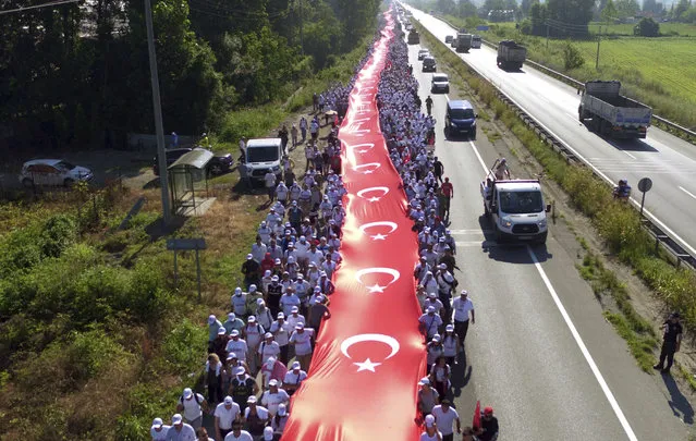 Thousands of supporters hold a 1.100 meter-long national flag as they follow Kemal Kilicdaroglu, the leader of Turkey's main opposition Republican People's Party, on the 17th day of his 425-kilometer (265-mile) march in Sakarya, some 220 kilometers from the capital Ankara, Turkey, Saturday, July 1, 2017. Kilicdaroglu and supporters are marching from the capital Ankara to an Istanbul prison to protest the conviction of one of his party's lawmakers. (Photo by AP Photo/Stringer)