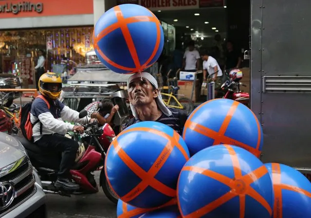 Joey Galang, 56, plays with rubber balls as he sells them for P100 each (about US$2) along a busy street in Manila, Philippines on Tuesday, May 31, 2016. Galang says he earns P300 (about US $6) on a slow day peddling the balls around the city. (Photo by Aaron Favila/AP Photo)