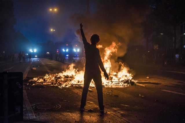 A protester posing in front of the burning barricade in Hamburg, Germany on July 7, 2017. Violent demonstrations against the Group of 20 summit meeting led to clashes between the police and protesters on the second consecutive night. (Photo by Daniel Dohlus/ZUMA Wire/Rex Features/Shutterstock)