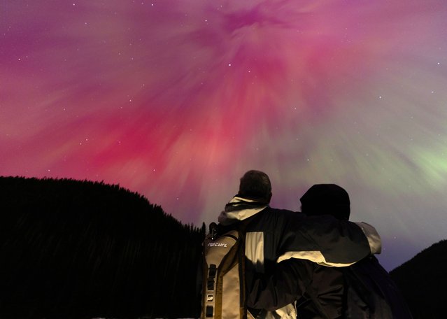 A couple watch the aurora borealis, commonly known as the northern lights on May 11, 2024 in Manning Park, British Columbia, Canada. (Photo by Andrew Chin/Getty Images)