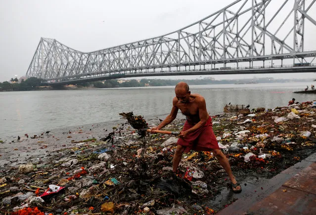 A man cleans garbage along the banks of the river Ganges in Kolkata, India, April 9, 2017. (Photo by Danish Siddiqui/Reuters)