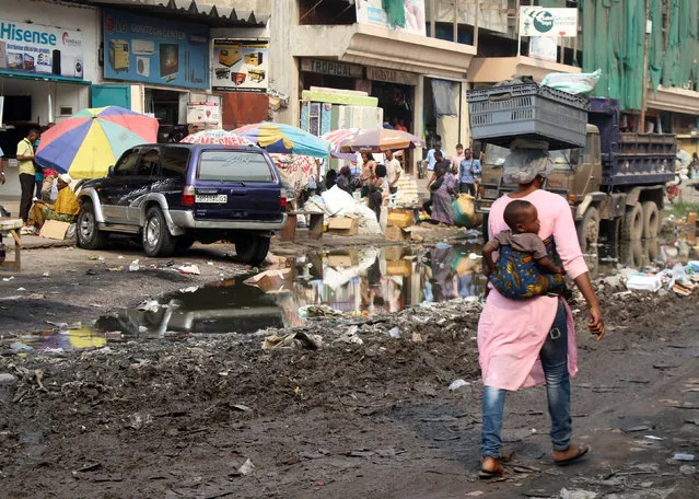 A woman carries her child as she walks along the streets in Kinshasa, capital of the Democratic Republic of the Congo, June 21, 2016. (Photo by Jean Robert N'kengo/Reuters)