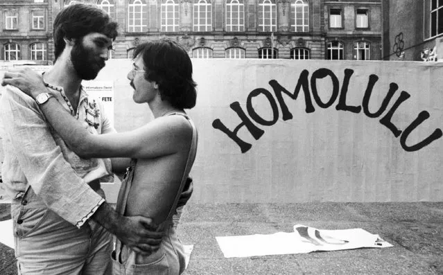 Two unidentified gay men embrace next to a banner reading “Homolulu” during a homosexual meeting at the campus of the Johann Wolfgang Goethe University in Frankfurt, Germany on July 26, 1979. The organizers are expecting more then 3.000 participants from Europe and prepare for a demonstration through the city. (Photo by Rolf Boehm/AP Photo)